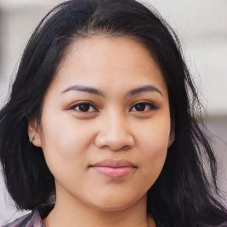 A headshot of a slightly smiling woman with dark hair